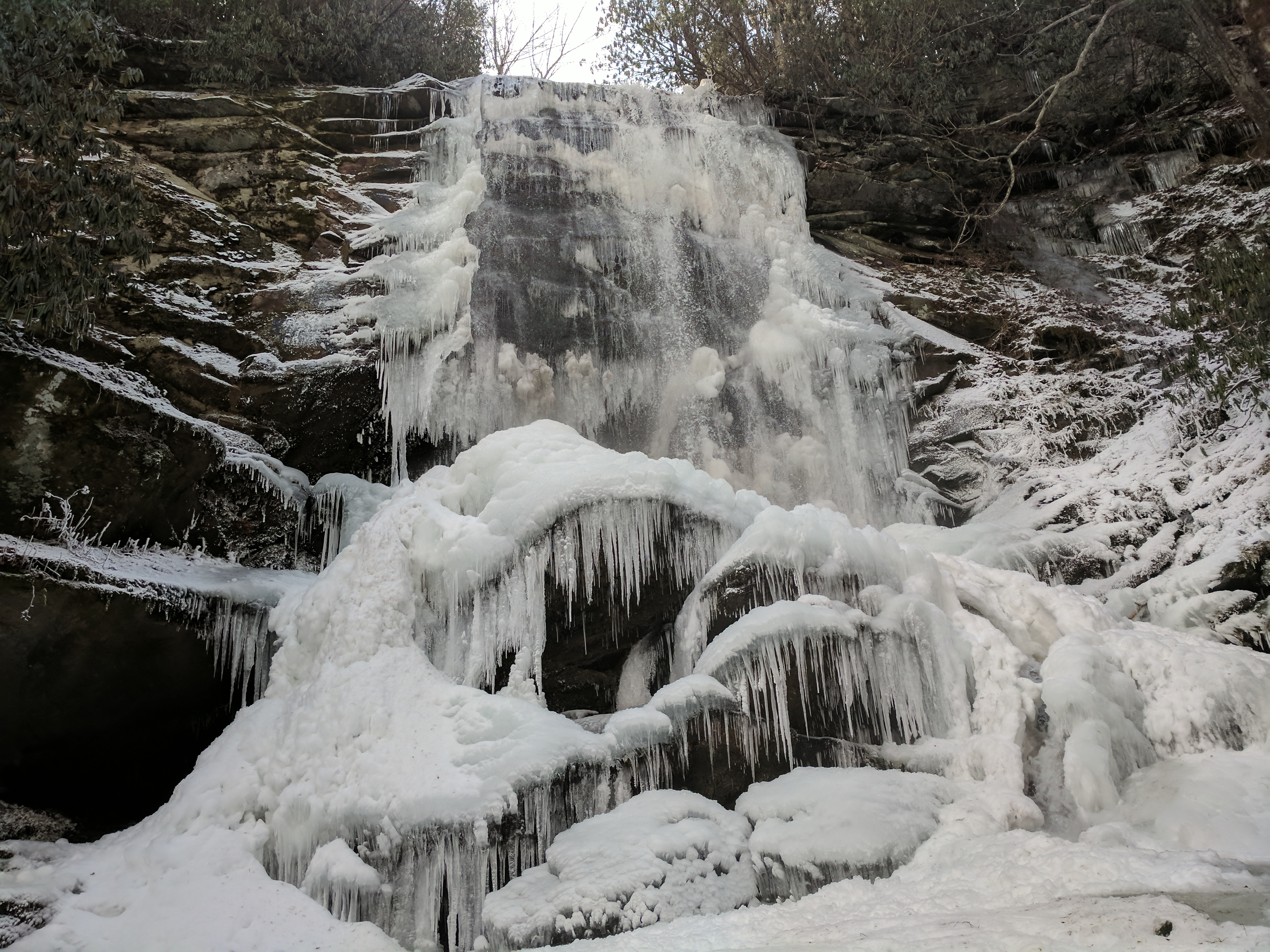 icicles and snow flow over the edge of the waterfall of the Blue Ridge Parkway