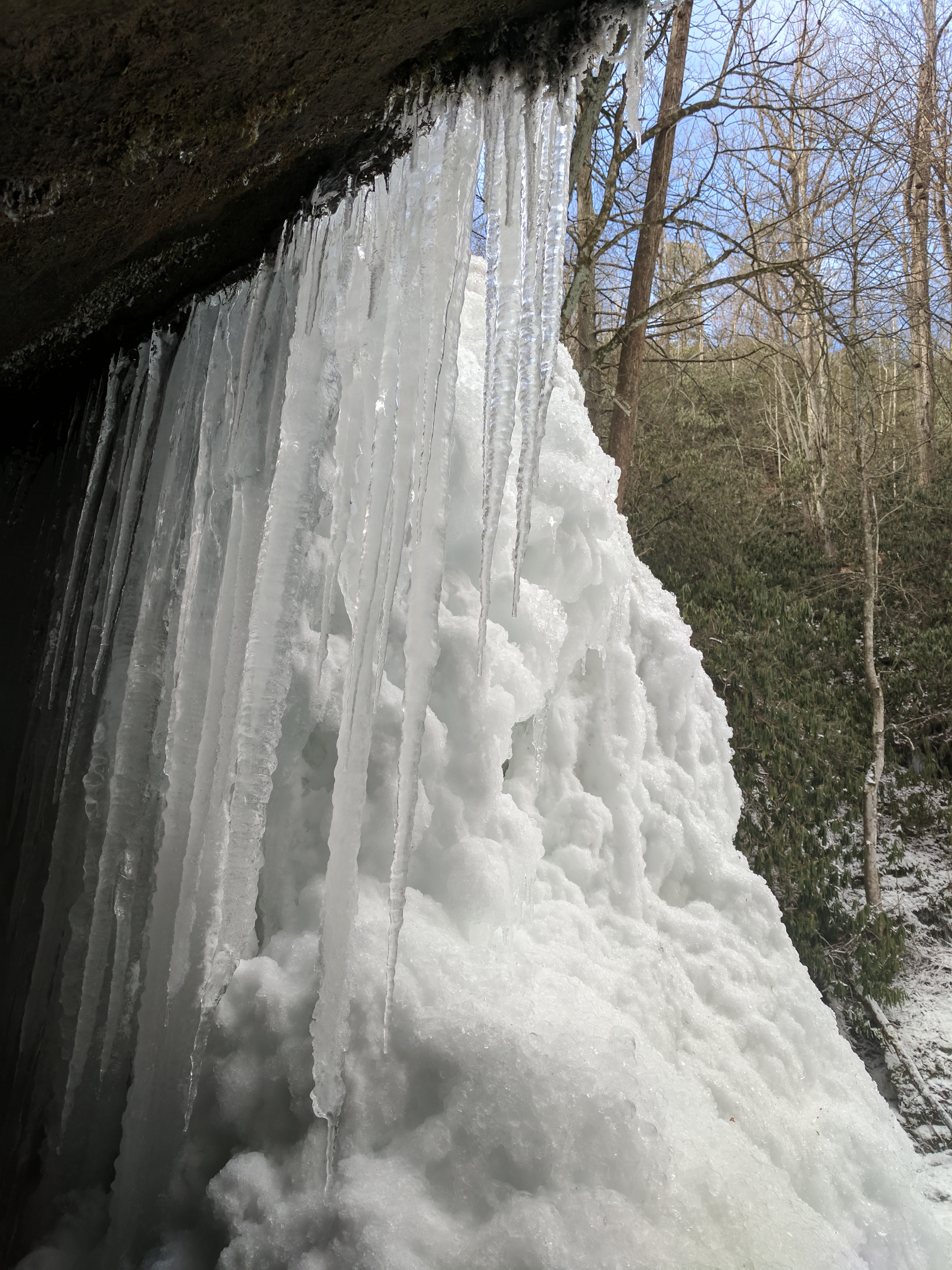 icicles and a snowdrift form on the face of an overhanging rock near the Blue Ridge Parkway